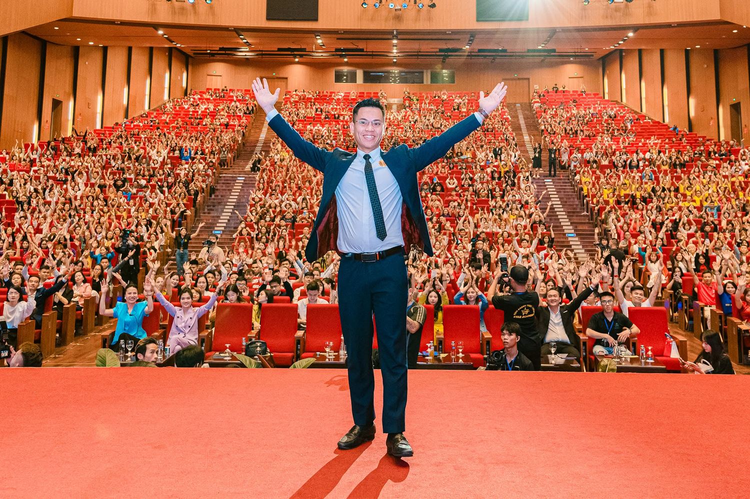 Lê Văn Cương dang tay chào hội trường đông kín người